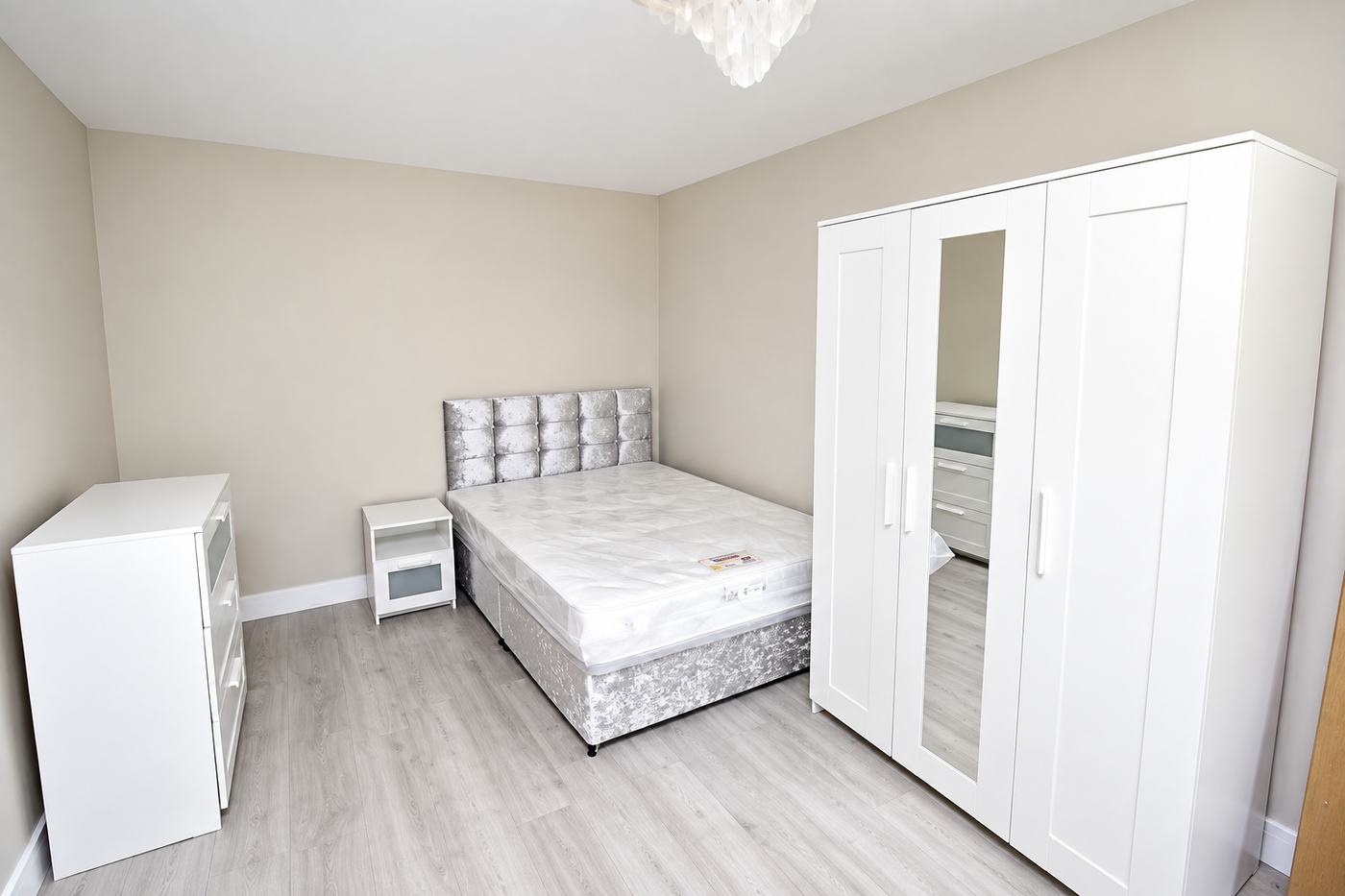 Double bedroom after an end of tenancy clean, with dust-free furniture and a clean laminate floor