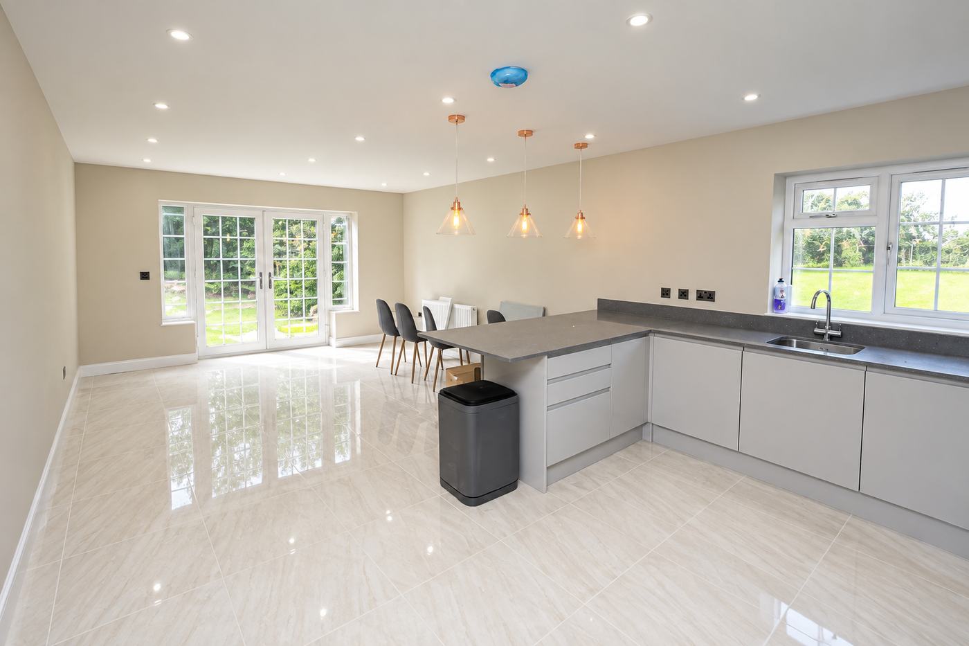 Open-plan kitchen-diner after an end of tenancy clean, with polished floor tiles and clear grey worktops