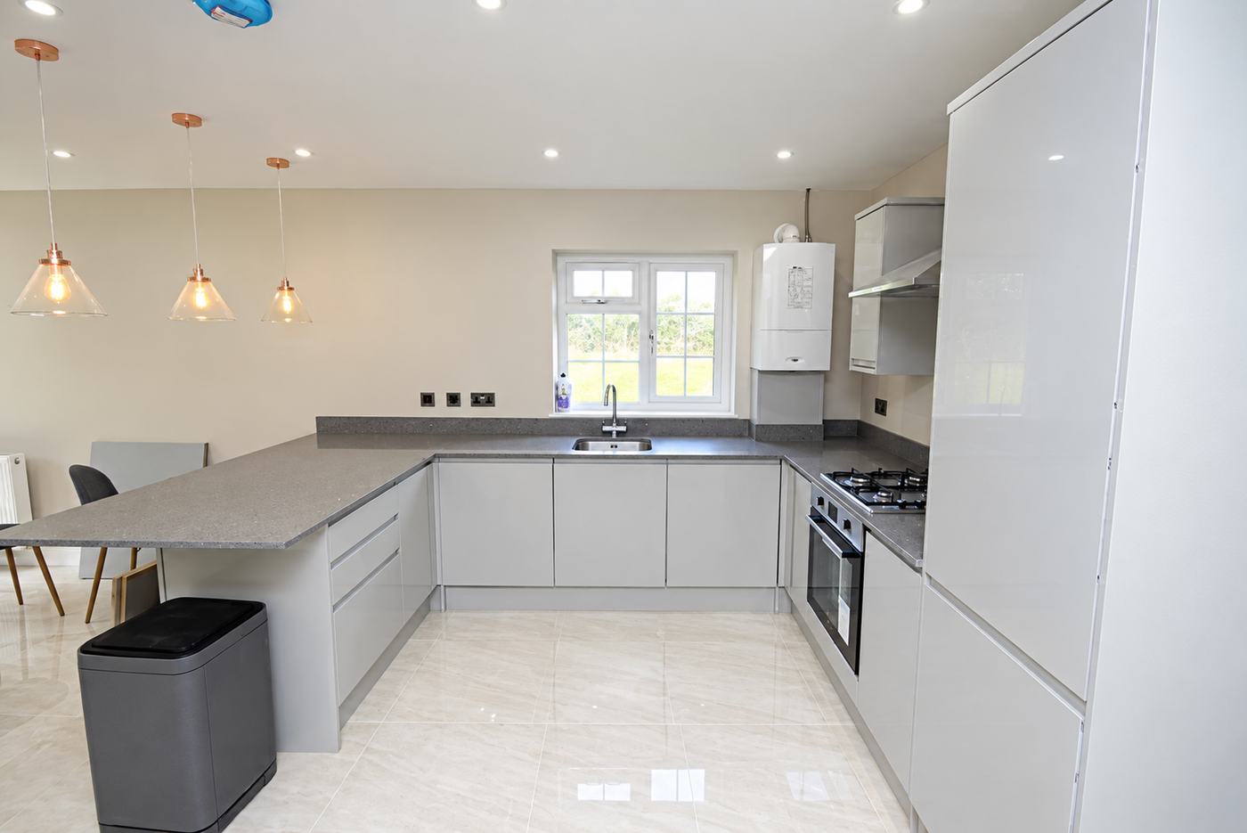 Kitchen after an end of tenancy clean: degreased hob and oven, clear worktops and a polished tiled floor